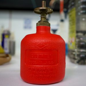 a red propane gas bottle sitting on a table
